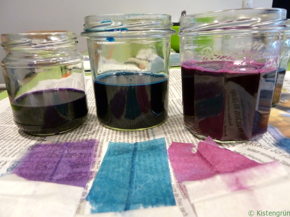 Drei Marmeladengläser mit violetter, blauer und roter Pflanzenfarbe