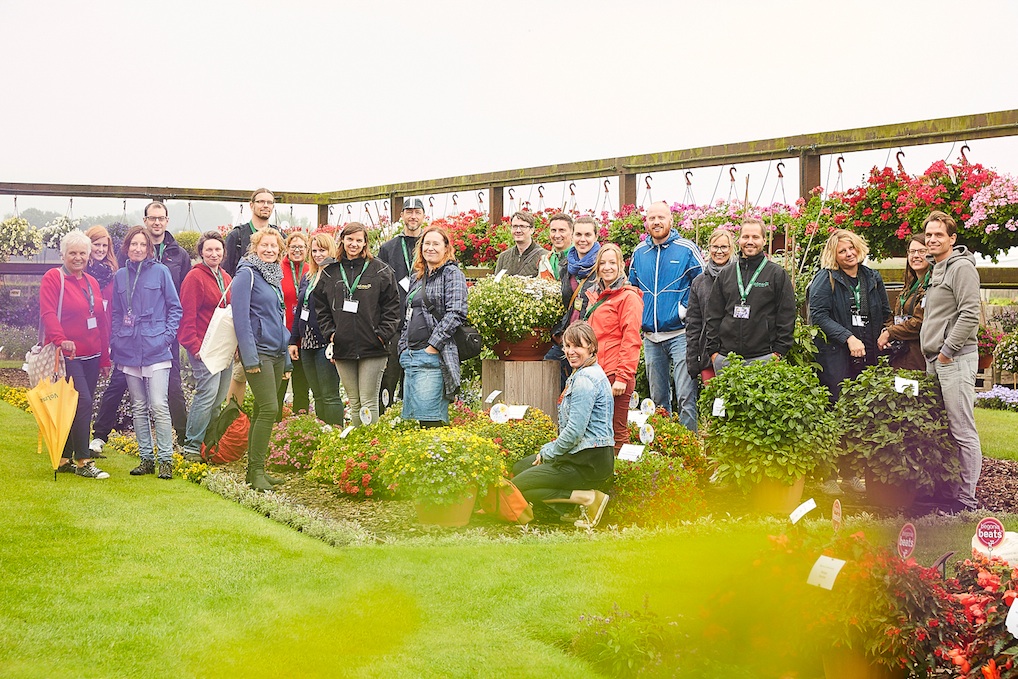 Gartenbloggertreffen: Gartenblogger stehen in einem Blumenbeet bei Volmary